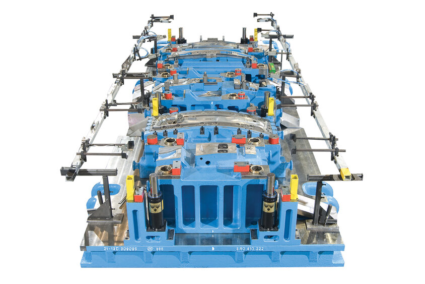 Ein blaues Kaltumformwerkzeug für die Produktion von B-Säulen aus höchstfestem Stahl, präsentiert auf einem weißen Hintergrund. Das Werkzeug ist mit Mechanisierungsgreifern ausgestattet, die auf dem Werkzeug montiert sind und seine Funktionalität für die industrielle Fertigung hervorheben.