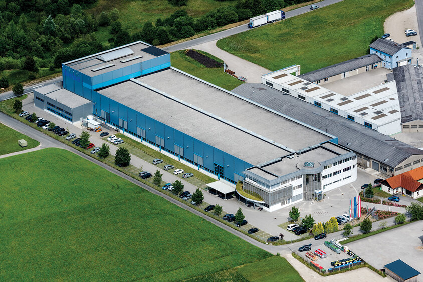 Luftaufnahme des weba Werkzeugbau Unternehmens in Dietach, aufgenommen aus einem Hubschrauber. Das Foto bietet eine umfassende Ansicht des Firmengeländes, einschließlich der Gebäude und umgebenden Strukturen, was die Größe und den Umfang des Unternehmensstandorts hervorhebt.